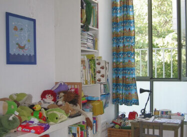 אחרי שיפוץ הדירה: אחד מחדרי הילדים - חלון גדול, המשקיף לתוך צמרות העצים, יוצר חדר יפה.
