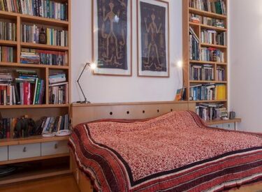 חדר השינה: מדפי ספרים, שידות לצידי המיטה, מקום אחסון בראש המיטה - כולם משולבים ברהיט אחד.