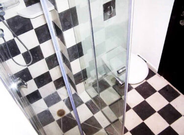 דוגמת שח-מט בשחור לבן, בחדר שירותים קטן מאוד
