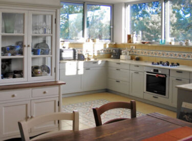 אחרי שיפוץ הדירה: עיצוב המטבח -שטיח מאריחים מעוטרים בריצוף וחיפוי קיר תואם לכך.
