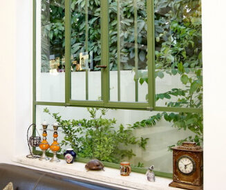 חלונות מפרופיל בלגי ברזל, צבוע ירוק. חלק תחתון קבוע, כך שאפשר להניח חפצים על אדן החלון הרחב.
