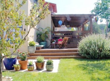 the living room balcony as seen from the garden, with the wooden stairs connecting them